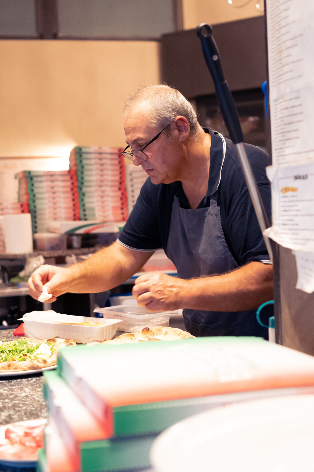 Pizzaiolo al lavoro al banco della pizzeria