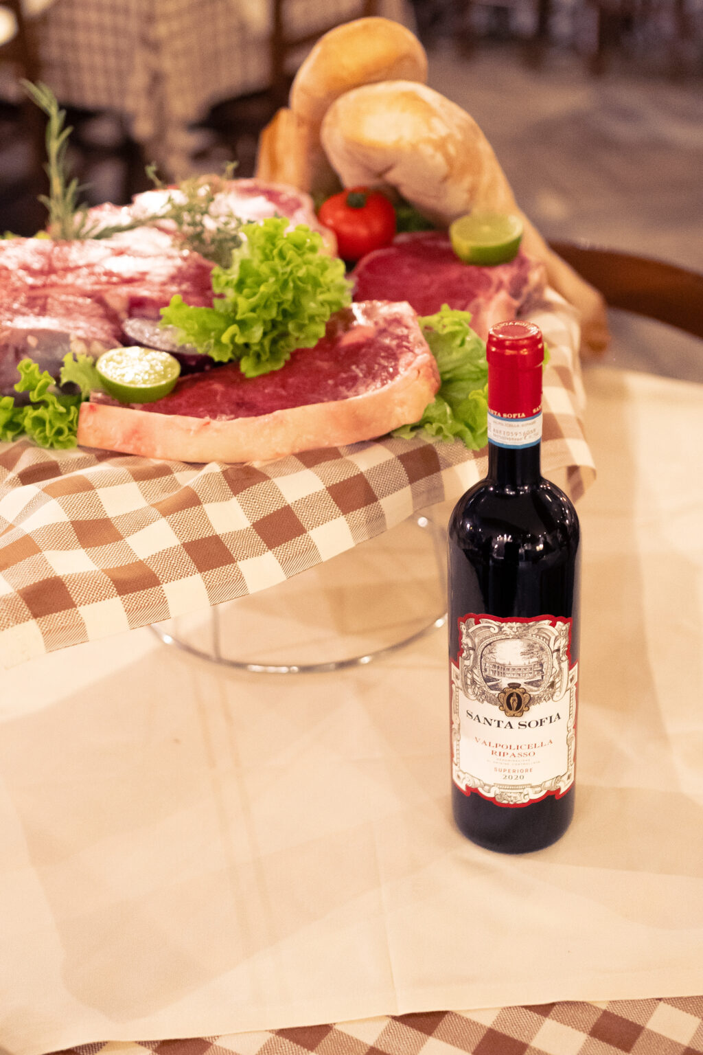 Tagli di carne in esposizione con una bottiglia di vino rosso