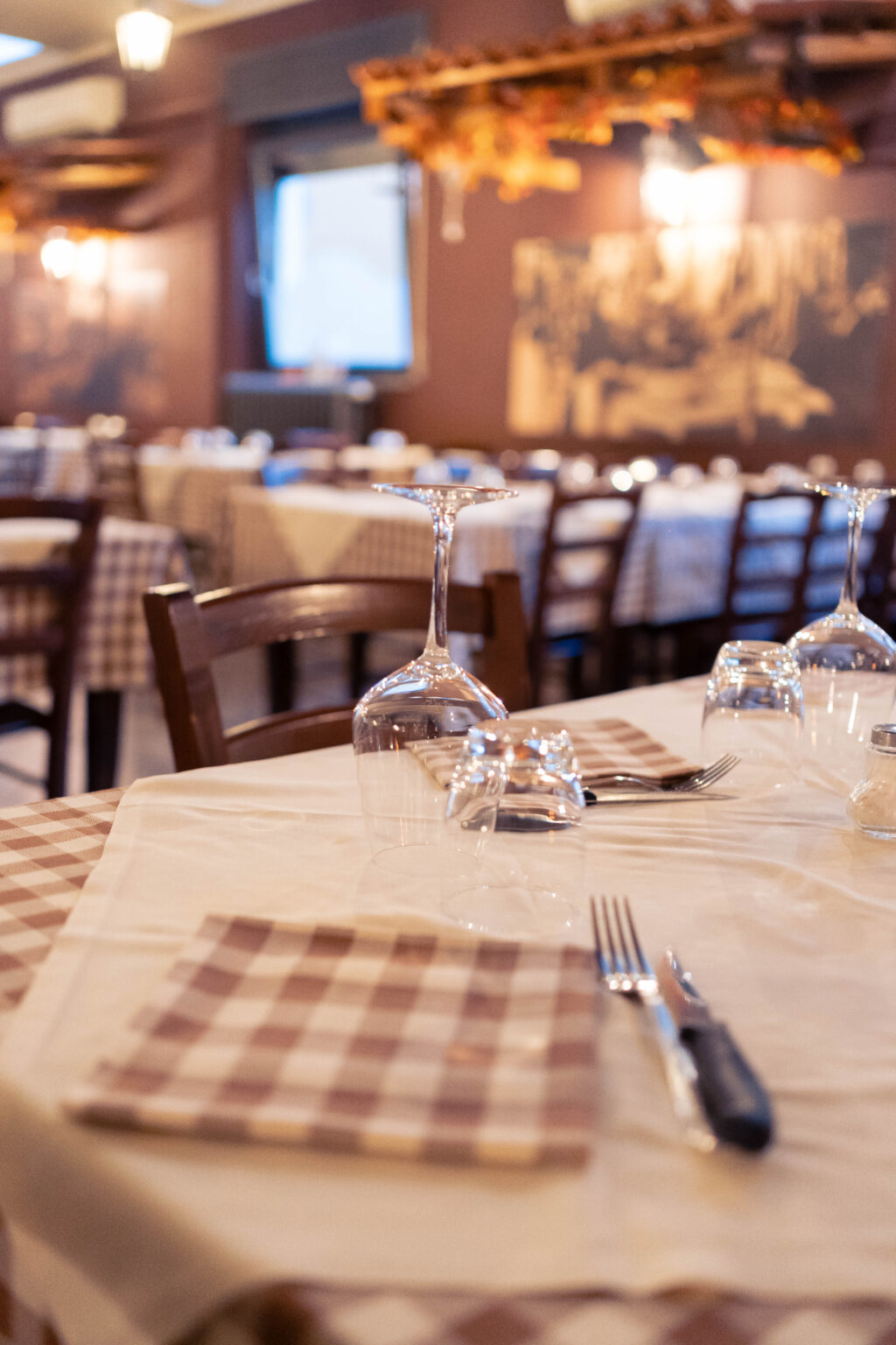Tavolo apparecchiato con tovaglia a quadri nella sala del ristorante