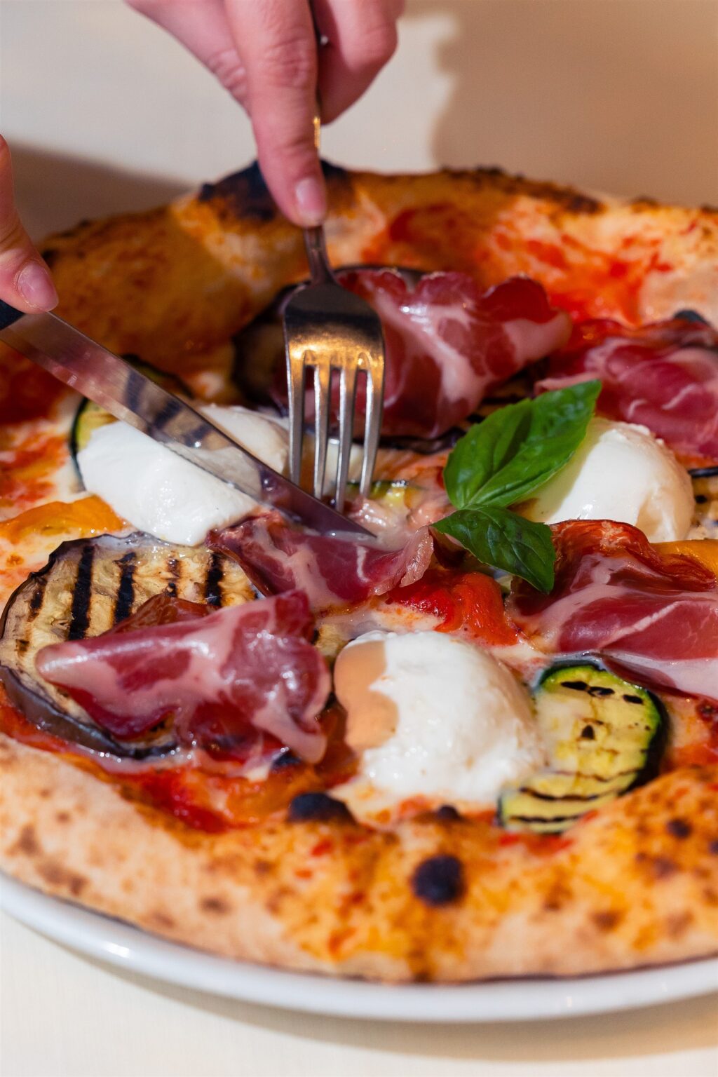 Pizza con prosciutto crudo, verdure grigliate e mozzarella